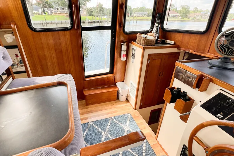 Mirage Yacht Photos Pics Cozy interior of a 1999 Nordic 32 boat with wooden accents and scenic water view.