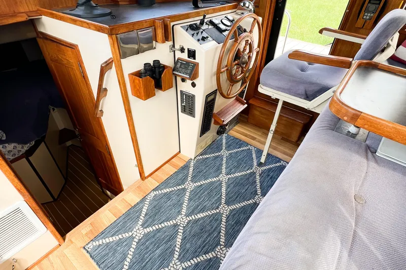 Mirage Yacht Photos Pics Interior of a 1999 Nordic 32 boat with wooden helm and nautical decor.
