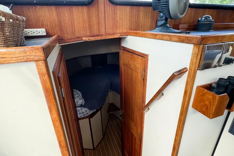 Mirage Yacht Photos Pics Cozy cabin interior of 1999 Nordic 32 boat with wooden accents and bedding.