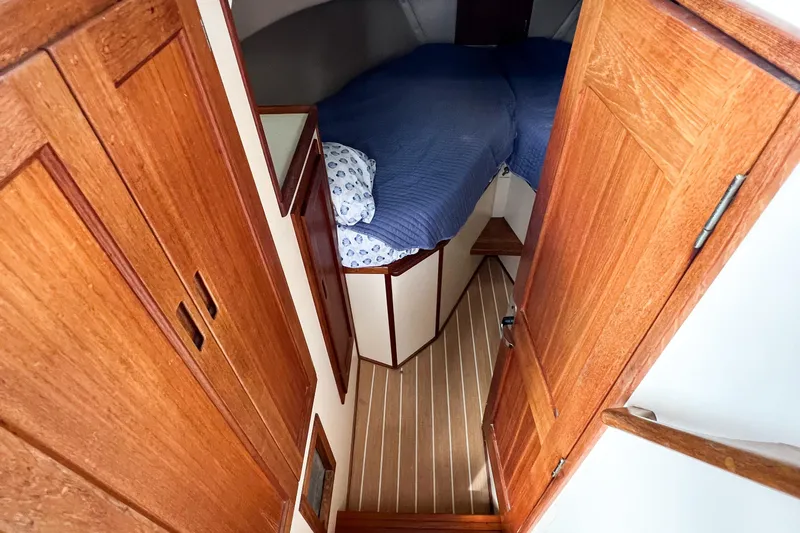 Mirage Yacht Photos Pics Cozy cabin interior of 1999 Nordic 32 boat with wooden finishes and blue bedding.