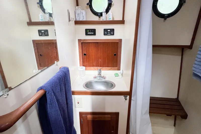 Mirage Yacht Photos Pics Bathroom interior of a 1999 Nordic 32 boat with sink and wooden accents.