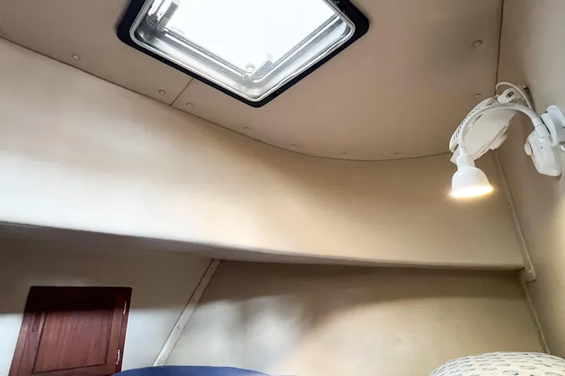 Mirage Yacht Photos Pics Interior cabin of a 1999 Nordic 32 boat with skylight and reading lamp.