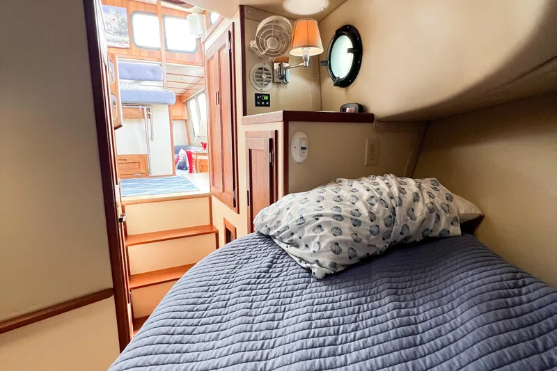 Mirage Yacht Photos Pics Cozy cabin interior of 1999 Nordic 32 boat with bed and wooden furnishings.