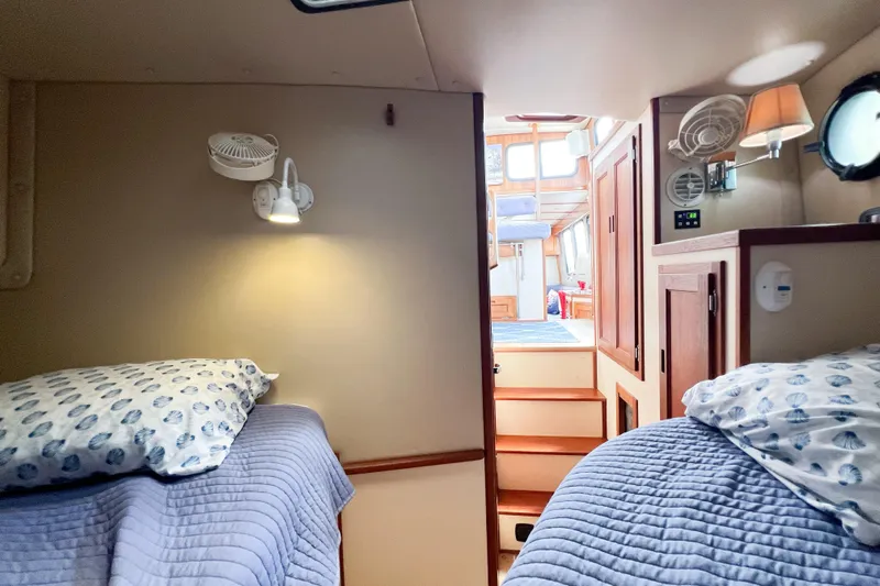 Mirage Yacht Photos Pics Cozy cabin interior of a 1999 Nordic 32 boat with twin beds and nautical decor.