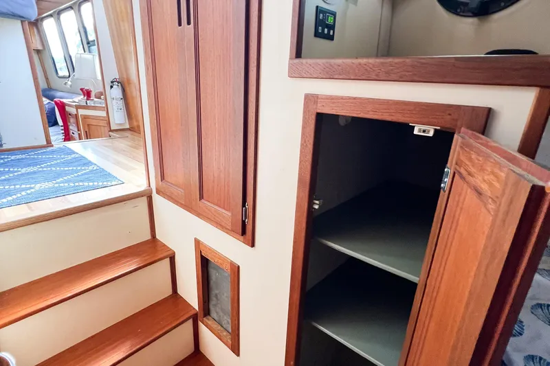 Mirage Yacht Photos Pics Interior of a 1999 Nordic 32 boat with wooden cabinetry and open storage.