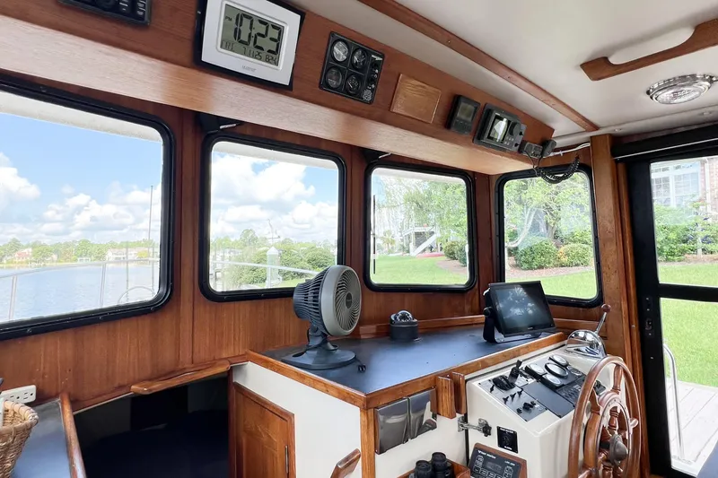 Mirage Yacht Photos Pics Interior of a 1999 Nordic 32 boat with wooden helm and navigation equipment.