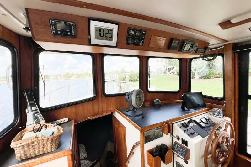 Mirage Yacht Photos Pics Interior of a 1999 Nordic 32 boat cockpit with wooden steering wheel and navigation equipment.