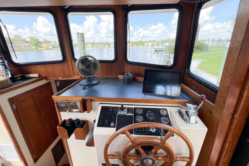 Mirage Yacht Photos Pics Interior of a 1999 Nordic 32 boat with steering wheel and navigation equipment.