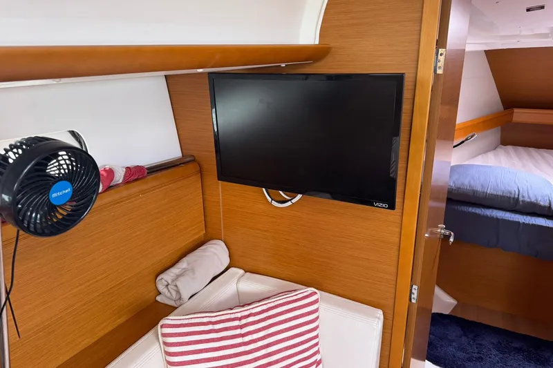 Kairos Yacht Photos Pics Interior of 2013 Jeanneau 409 yacht with TV, fan, and cozy seating area.