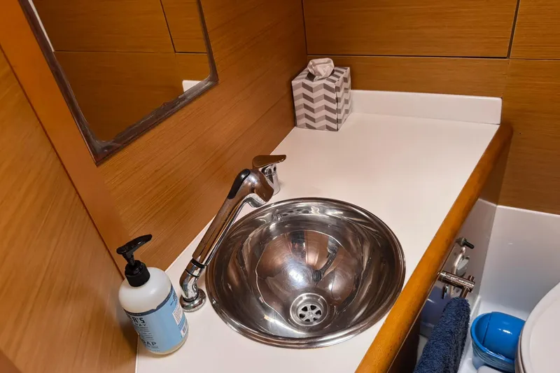Kairos Yacht Photos Pics Bathroom sink area in a 2013 Jeanneau 409 yacht, featuring a stainless steel basin.