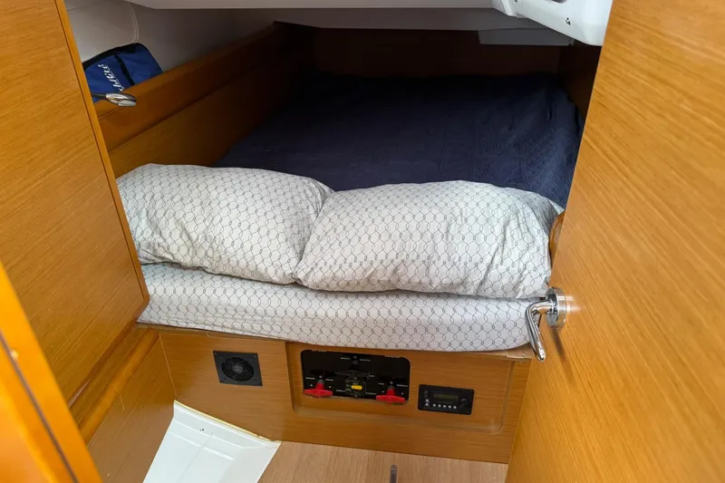 Kairos Yacht Photos Pics Cozy cabin interior of 2013 Jeanneau 409 sailboat with bed and wooden finish.