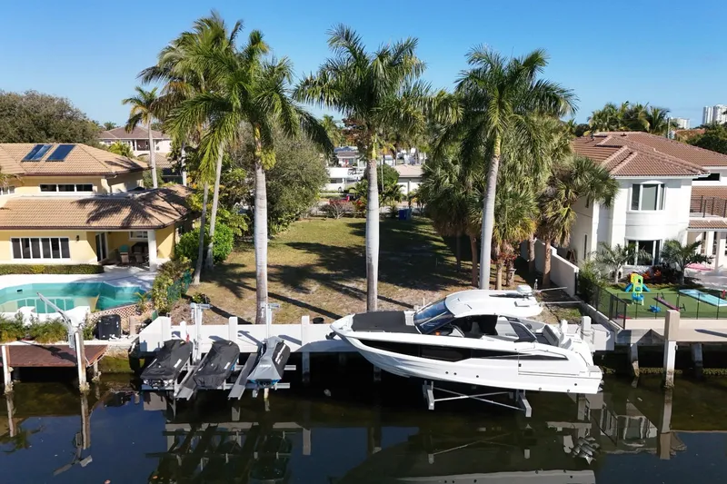  Yacht Photos Pics 2024 Galeon 325 GTO yacht docked by waterfront homes with palm trees.