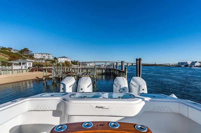  Yacht Photos Pics 2025 Front Runner 43 Catamaran docked by scenic waterfront homes and clear blue sky.
