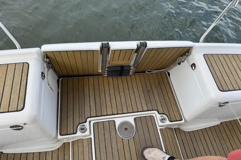 Kairos Yacht Photos Pics Jeanneau 409 boat deck with teak flooring and water view.