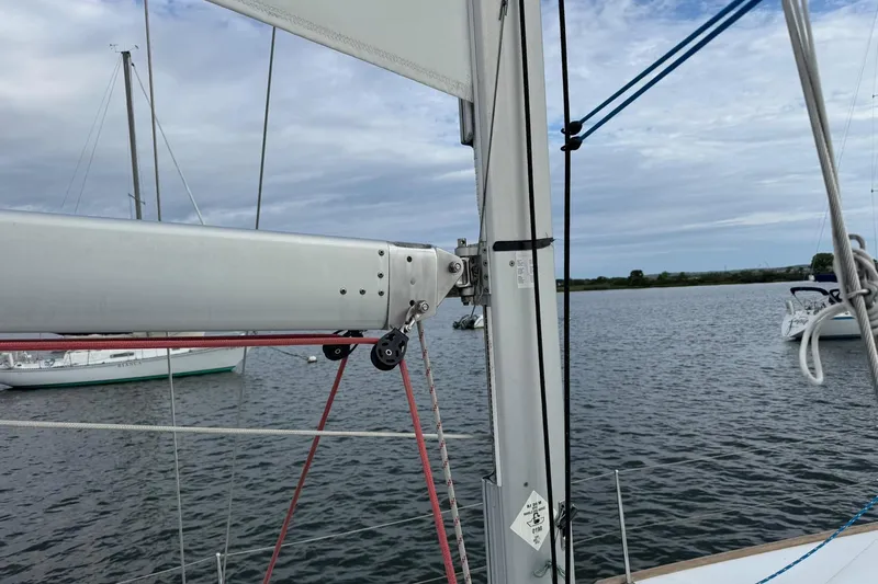 Kairos Yacht Photos Pics Jeanneau 409 sailboat mast and rigging on calm water, overcast sky.
