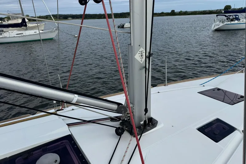 Kairos Yacht Photos Pics Jeanneau 409 sailboat deck with mast and rigging, anchored in calm waters.