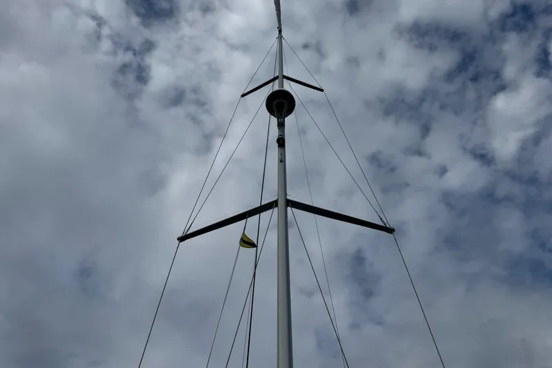 Kairos Yacht Photos Pics Mast of Jeanneau 409 sailboat against a cloudy sky.