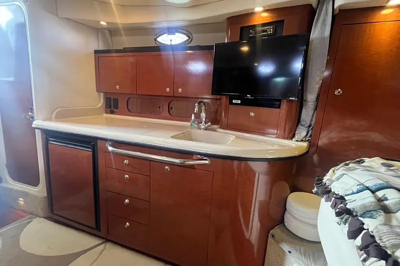 Chance Encounter Yacht Photos Pics 2004 Sea Ray 340 Sundancer interior with kitchenette, TV, and wooden cabinetry.