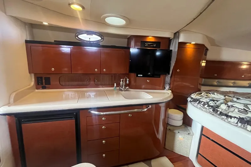 Chance Encounter Yacht Photos Pics 2004 Sea Ray 340 Sundancer interior with kitchenette, TV, and bed.