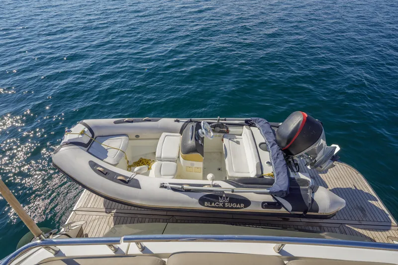 Black Sugar Yacht Photos Pics Inflatable boat "Black Sugar" on Princess V78 yacht, 2010, docked on calm blue water.