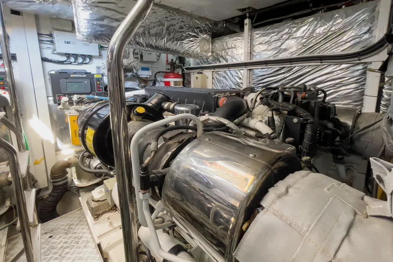 Black Sugar Yacht Photos Pics Engine room of a 2010 Princess V78 yacht, featuring Caterpillar machinery and metallic components.