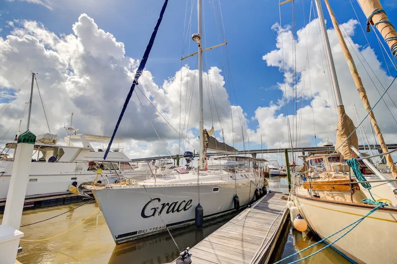 Grace Yacht Photos Pics Sailboat "Grace" docked, Beneteau 510, 1994 model, under a bright blue sky with clouds.