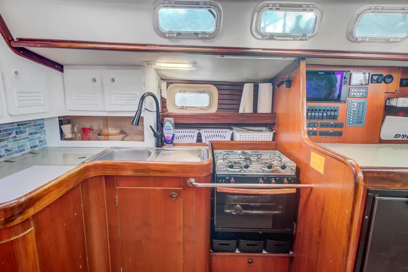 Grace Yacht Photos Pics Interior of a 1994 Beneteau 510 yacht kitchen with stove, sink, and storage.
