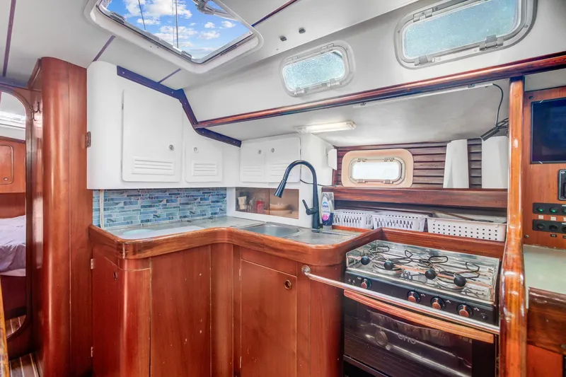 Grace Yacht Photos Pics Interior of 1994 Beneteau 510 yacht kitchen with wood cabinetry and modern appliances.