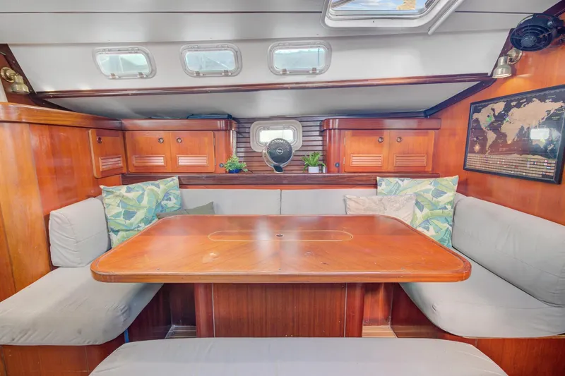 Grace Yacht Photos Pics Cozy interior of 1994 Beneteau 510 sailboat with wooden dining area and cushions.