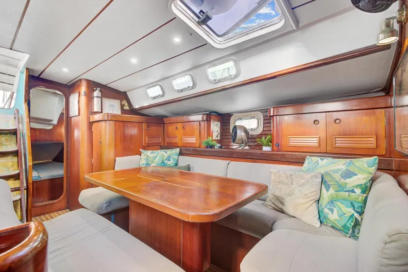 Grace Yacht Photos Pics Luxurious interior of a 1994 Beneteau 510 yacht with wooden furnishings and cozy seating.