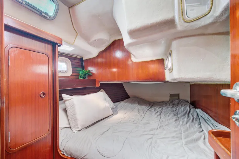 Grace Yacht Photos Pics Cozy cabin interior of 1994 Beneteau 510 sailboat with wooden accents and bedding.