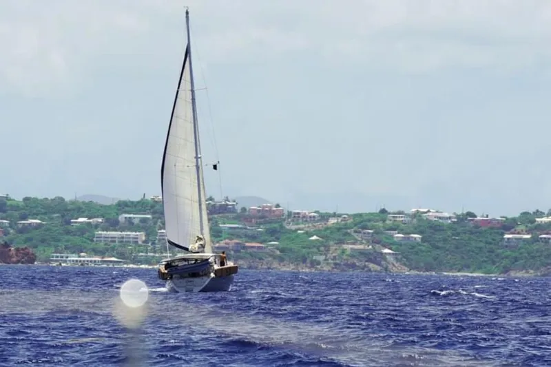 Grace Yacht Photos Pics Sailing yacht Beneteau 510 (1994) on open sea near lush coastline.