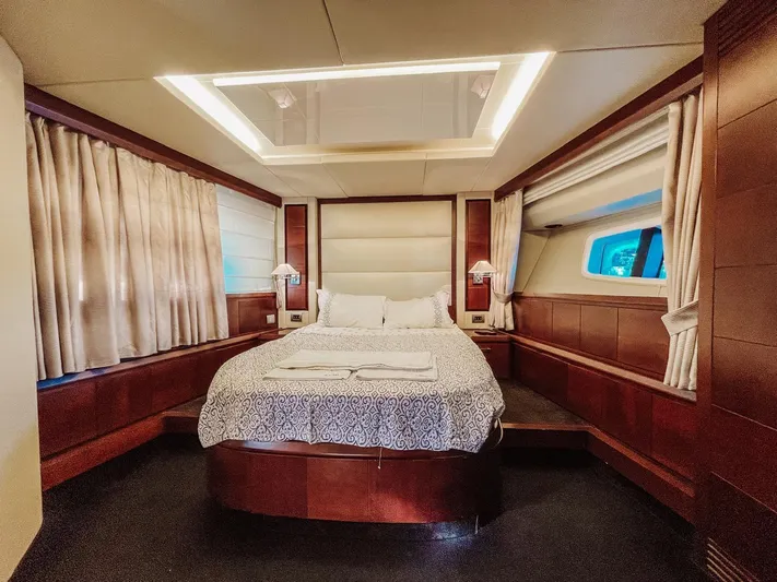  Yacht Photos Pics Luxurious bedroom interior of 2009 Azimut 75 yacht with elegant wood paneling and cozy bedding.