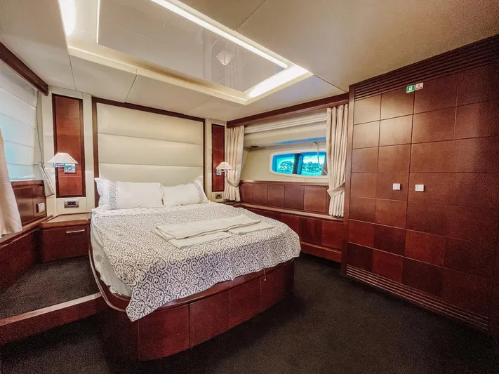  Yacht Photos Pics Luxurious bedroom interior of 2009 Azimut 75 yacht with elegant wood paneling and cozy bedding.