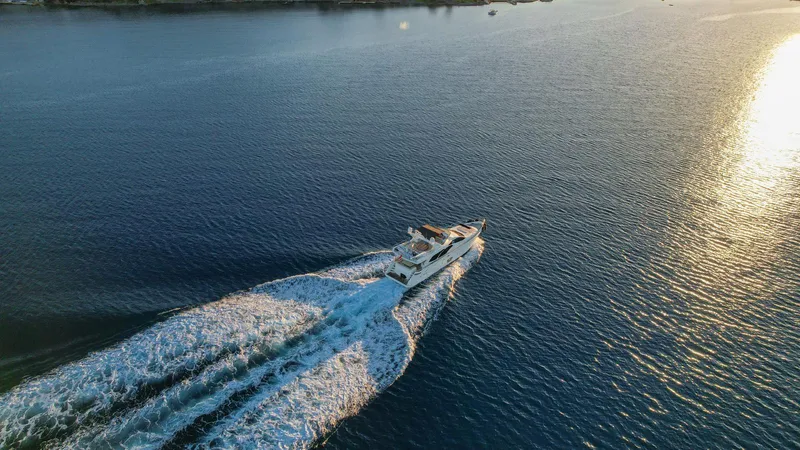  Yacht Photos Pics Aerial view of 2009 Azimut 75 yacht cruising on open water at sunset.