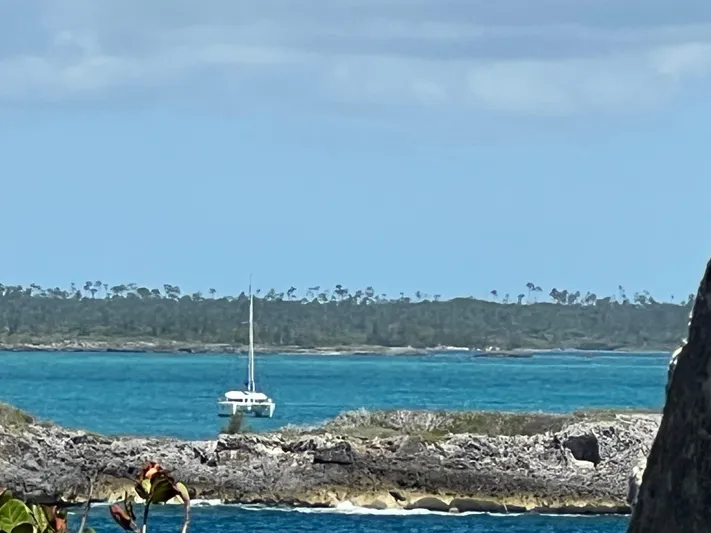 Feel The Moon Yacht Photos Pics Sailboat on turquoise waters near rocky shore, Lagoon 400 Owner's Version, 2010 model.