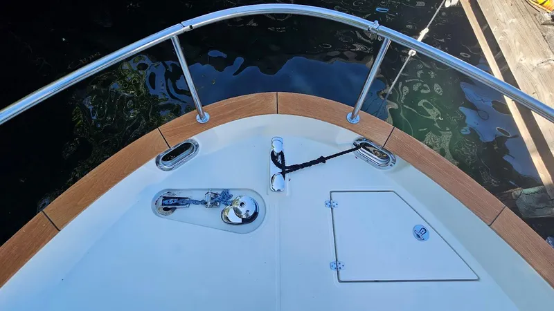 Bryanne Yacht Photos Pics Bow of 2014 Greenline 40 boat with anchor and railing, docked by water.