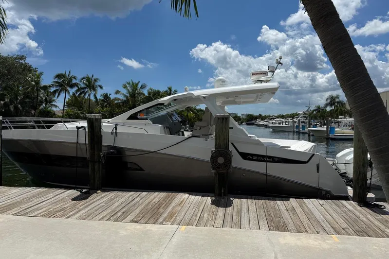 Veloce Yacht Photos Pics 2017 Azimut Verve 40 yacht docked by palm trees under a blue sky.