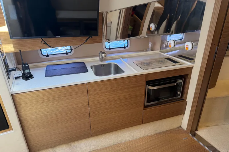 Veloce Yacht Photos Pics 2017 Azimut Verve 40 yacht kitchen with sink, microwave, and TV. Modern wood cabinetry.