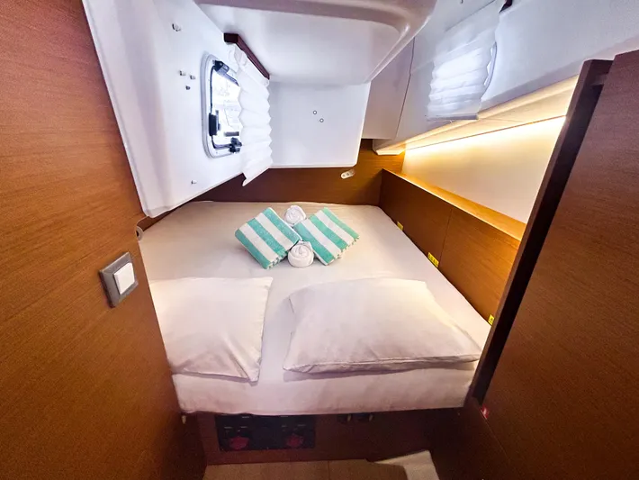 Soca Sleigh Yacht Photos Pics Cozy cabin interior of 2024 Jeanneau Sun Odyssey 380 yacht with bed and porthole.