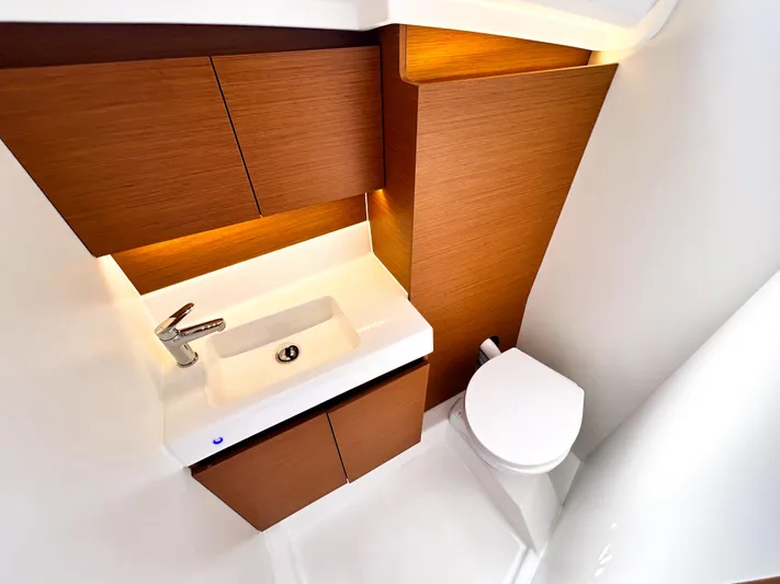 Soca Sleigh Yacht Photos Pics 2024 Jeanneau Sun Odyssey 380 bathroom with modern sink, wooden cabinetry, and toilet.