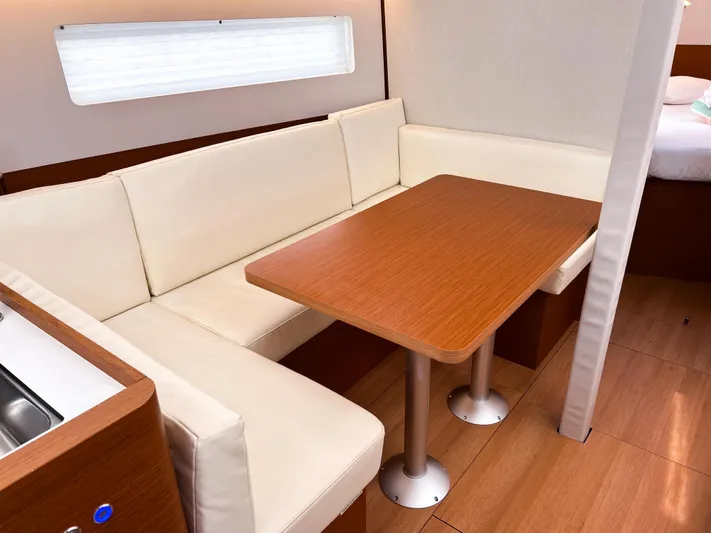Soca Sleigh Yacht Photos Pics 2024 Jeanneau Sun Odyssey 380 interior with cozy dining area and wooden table.