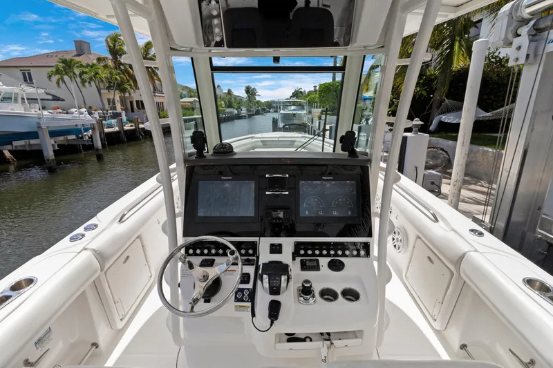  Yacht Photos Pics 2014 Boston Whaler 320 Outrage boat cockpit with steering wheel and control panel.