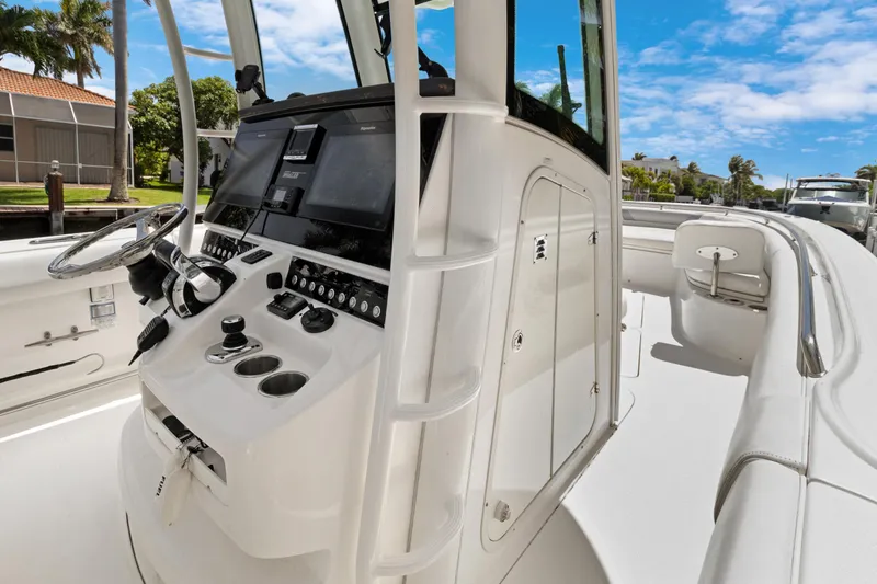  Yacht Photos Pics 2014 Boston Whaler 320 Outrage boat cockpit with steering wheel and control panel.