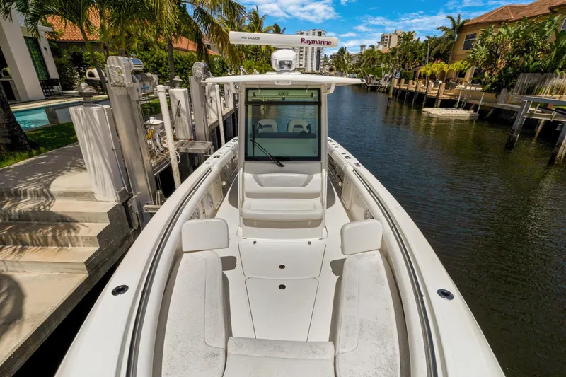  Yacht Photos Pics 2014 Boston Whaler 320 Outrage boat docked in a scenic canal setting.