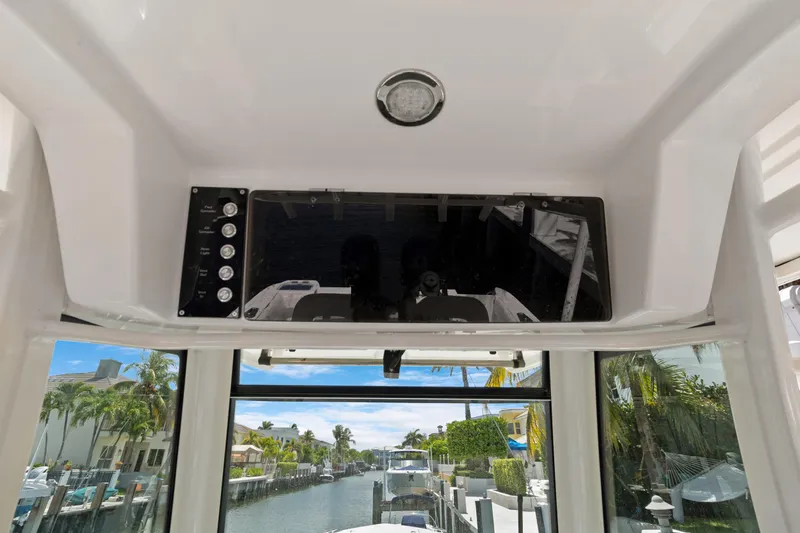  Yacht Photos Pics 2014 Boston Whaler 320 Outrage helm view with control panel and canal backdrop.