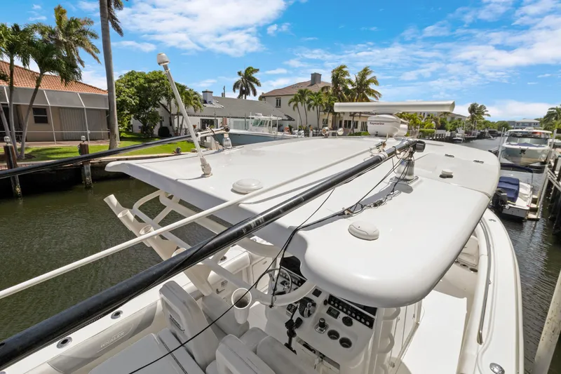  Yacht Photos Pics 2014 Boston Whaler 320 Outrage docked in a sunny canal setting.