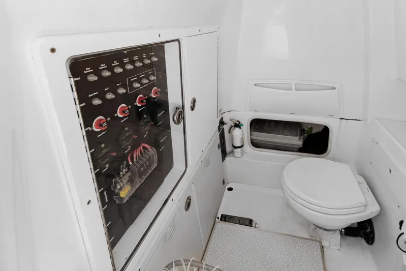  Yacht Photos Pics 2014 Boston Whaler 320 Outrage interior with control panel and marine toilet.