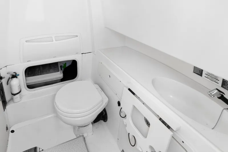  Yacht Photos Pics 2014 Boston Whaler 320 Outrage boat bathroom with toilet, sink, and storage compartment.