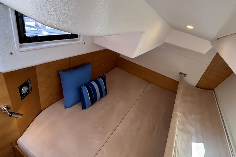 Abide Yacht Photos Pics Cozy cabin interior of 2018 X-Yachts X4.9 with cushions and wooden accents.